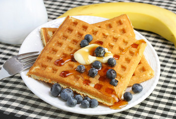 Homemade waffles with syrup and fresh blueberries