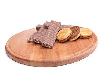 Wafers and cookie lie on the round board.