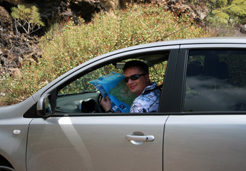 The man in the car with a map  in hands