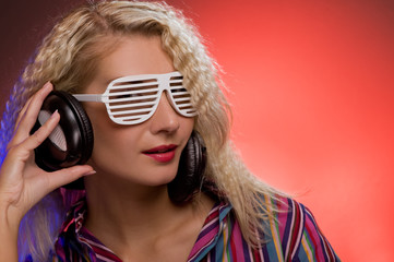 Stylish blond woman with shutter glasses and headphones