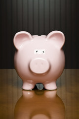 Piggy bank on a table with dollar sticking out of it’s top