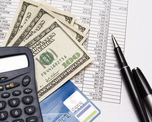 financial statement, calculator, banknotes and pen