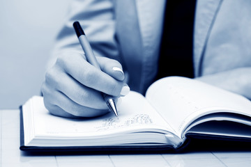 Businesswoman writing.