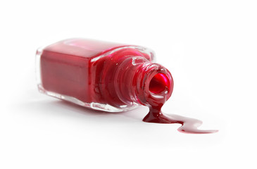 red nail polish pouring from overturned bottle