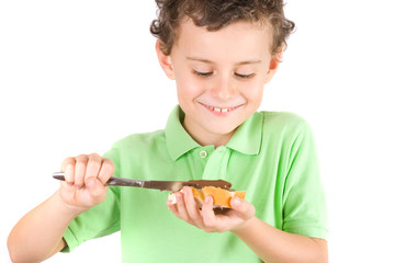 Boy spreading peanuts butter on bread
