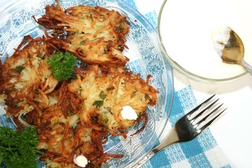 Potato pancakes , served with sour cream. Isolated.