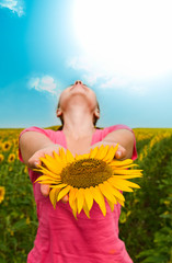 girl with a sunflower against the sky