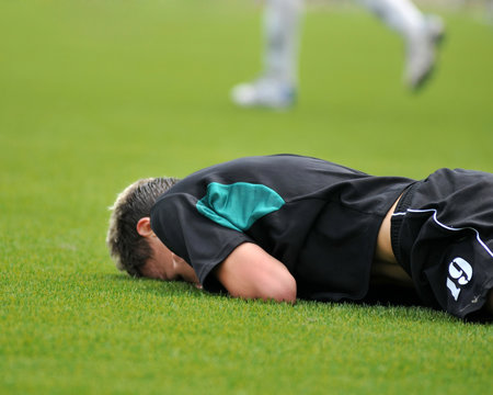 Young soccer man lying on the grass