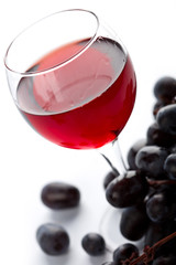 glass of red wine and grapes isolated