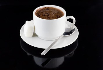 Cup of hot chocolate, sugar, on a black background.