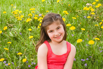 Girl Smiling in Front of Flowers