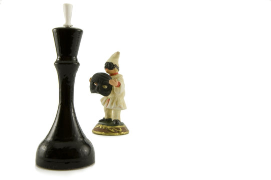 One chess figure and ceramic figurine of the clown on a white ba