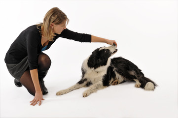 jeune femme récompensant son chien avec une friandise