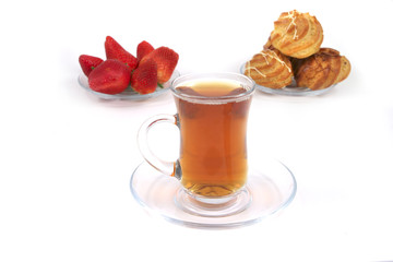 tea cup with eclair and strawberry