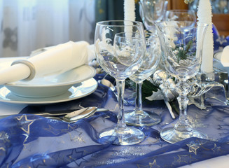 Decorative Christmas table serving. Glasses, candles, plates.