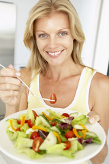 Obraz na płótnie Canvas Mid Adult Woman Eating A Healthy Salad