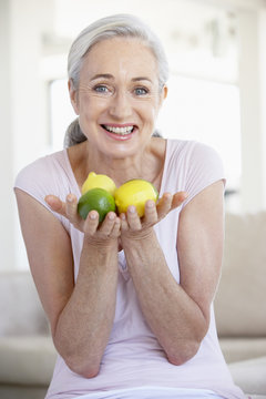 Senior Woman Holding Fruit And Smiling At The Camera