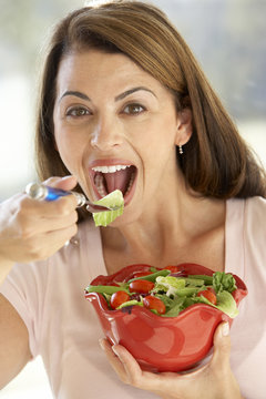Mid Adult Woman Eating A Fresh Green Salad