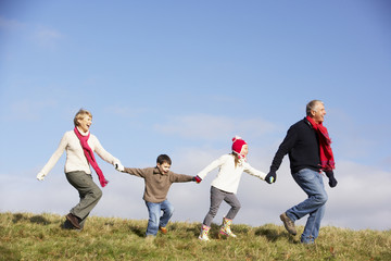 Grandparents And Grandchildren Running In The Park