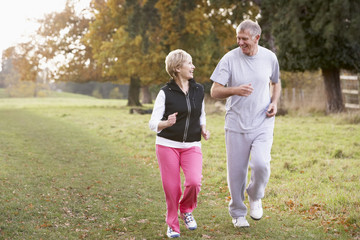 Senior Couple Power Walking In The Park