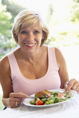 Obraz na płótnie Canvas Middle Aged Woman Eating An Al Fresco Lunch