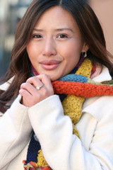 Winter: Asian Girl in White Coat and Colorful Knit Scarf Warming