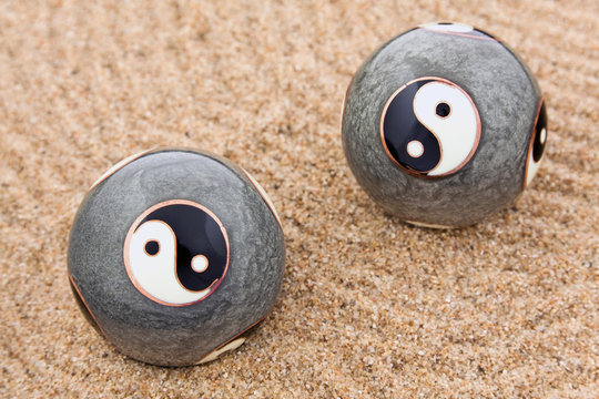 Zwei Qigong Kugeln für die innere Ruhe liegen auf Sand