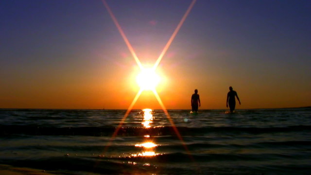Two guys and sunset over the sea HD