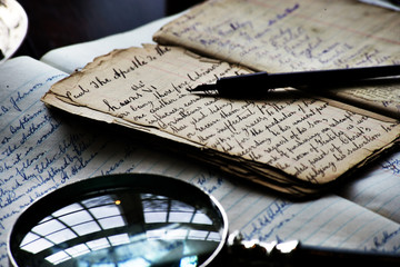 Desktop Scene with old ink pen, notebook, book, writing