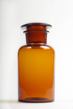 Old brown pharmacy jar on white background. Vertical. Copy space.