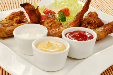 Grilled chicken wings with baked potatoes and vegetable salad