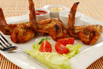 Grilled chicken wings with baked potatoes and vegetable salad