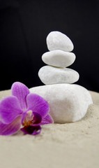 Fototapeta na wymiar Kamienie Spa z orchidea na piaszczystych