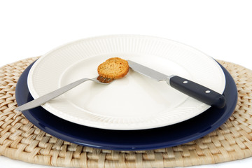 plate on blue under-plate on raffia place-mat knife & fork