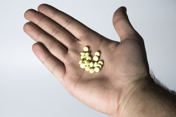 Hand with yellow pills