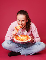 young woman with pizza sitting on the floor