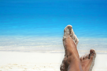 feet of a woman on a tropical beach