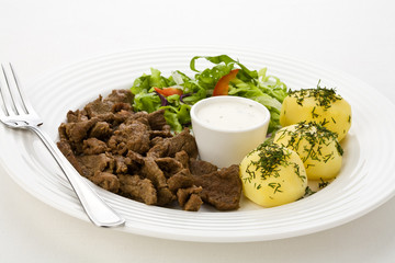 Grilled meat with boiled potatoes, sauce and vegetable salad