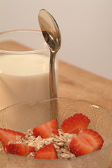 Erdbeermüsli in einer Glasschale und Milch