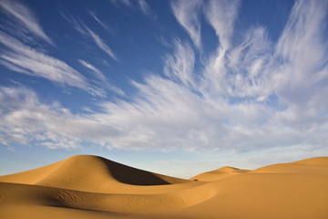 Fototapeta na wymiar desert dunes with cloudy blue sky