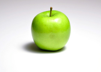 Green apple on a white background with a heavy shadow
