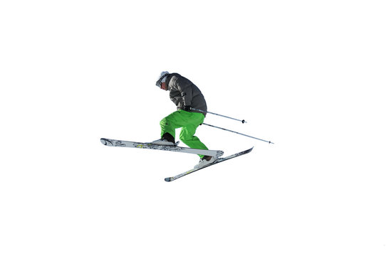 skier in bright green trousers jumping in the air