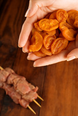 Chefs hands with apricots and beef kebabs