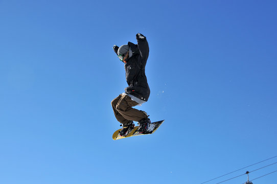 girl snowboarder on a high jump