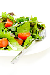 Fresh salad with fork on white background