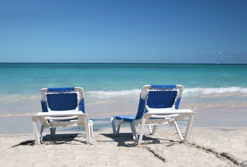 Fototapeta na wymiar Tropical Paradise - Two Beach Chairs on White Sand Beach and Oce