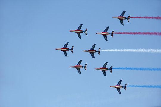 Fototapeta Formation of jet planes with coloured smoke trails