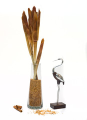 Figure of a crane and glass vase with a dry plant