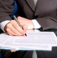 businessman writing on a form