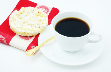 Coffee with a snack of a low calorie rice cake with a napkin.